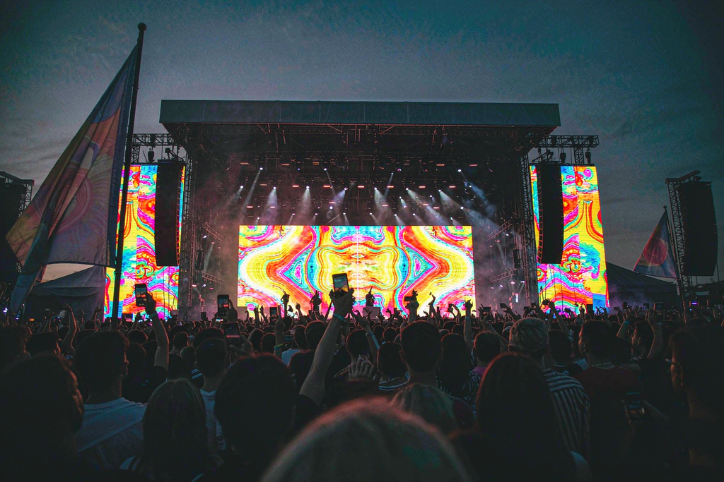 Outdoor music festival main stage with rental LED wall screens, main backdrop plus two side screens at dusk