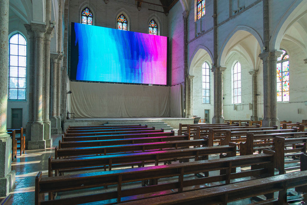 Church LED wall staying vivid and readable in a sunlit sanctuary with large windows and stained glass
