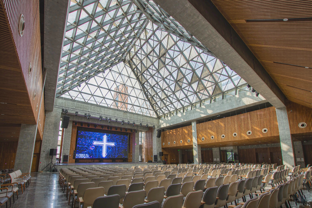Church auditorium with a full glass skylight where the LED screen stays vivid and readable in broad daylight
