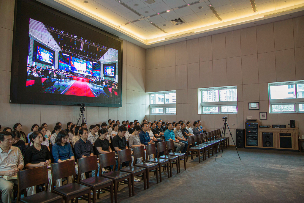 Church satellite overflow room where the streamed service looks identical on a wall-mounted LED screen