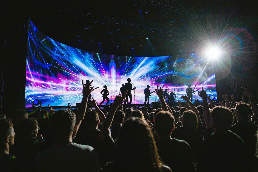 Massive curved micro LED screen backdrop at a live concert venue built from modular tiles