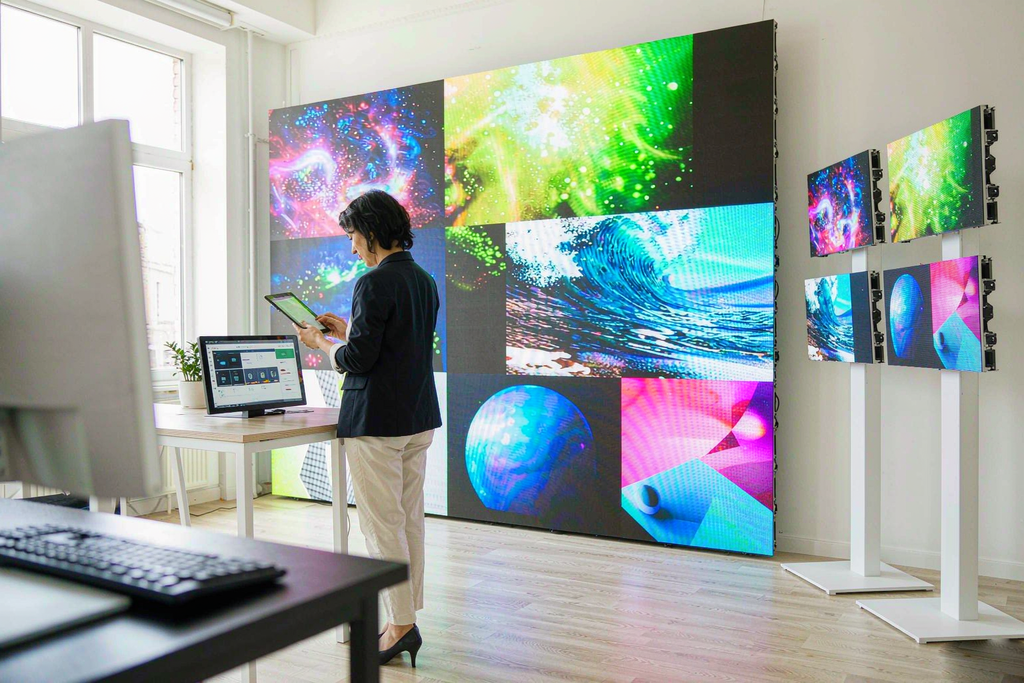 Operator managing multiple LED screen wall zones remotely from a tablet